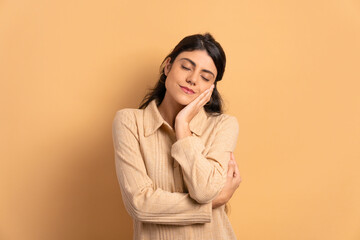 confident young woman embracing self, hugging in beige colors. self love, care concept.