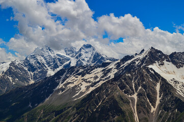 Beautiful peaks of the Western Caucasus on a sunny summer day. Mountains covered with snow and glaciers