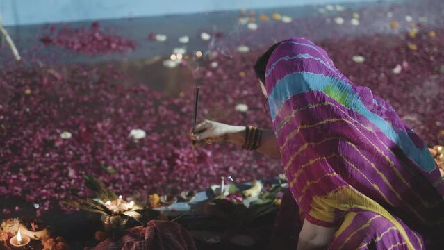 indian devotee preparing for holy rituals at chhath festival at river shore at night