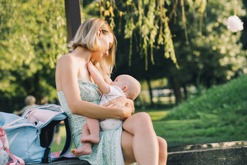 Beautiful mother breastfeeding baby. Young woman breast feeding her newborn baby. Concept of...