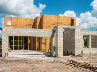 Street view of a bi-level single-family house under construction, with garage entranceway at left,...