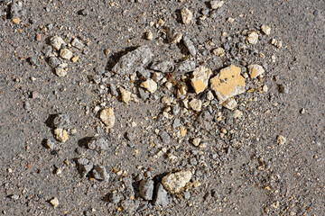 Small fragments of a broken stone slab on the asphalt