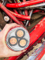 A hand holding a heavy duty copper power cable to show the amount of copper running through