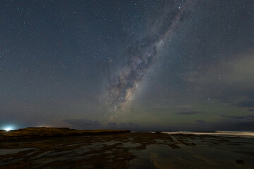 Milky way view from rocky coastline.