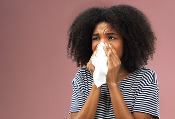 Stress, tissue and sick woman in studio blowing nose for allergies, flu or covid emergency on pink...