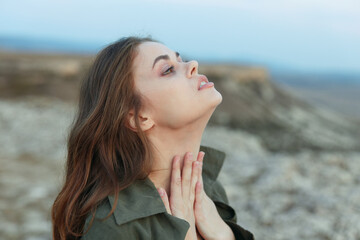 serene young woman gazes at the sky from atop a majestic mountain peak