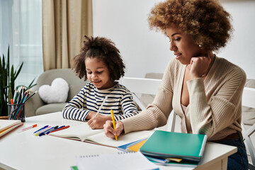 A happy African American mother and daughter focus on their homework together at home.