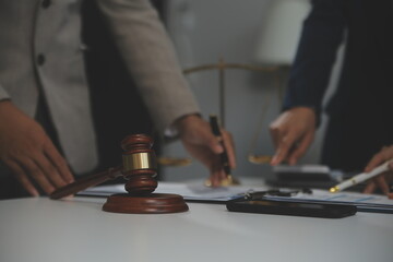 Judge gavel with Justice lawyers having team meeting at law firm background. Concepts of Law and...