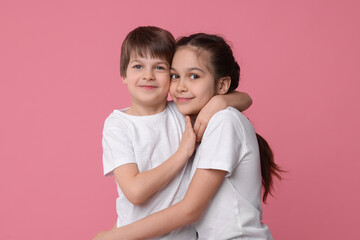 Happy brother and sister on pink background