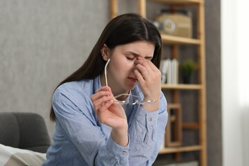 Overwhelmed woman with glasses suffering at home