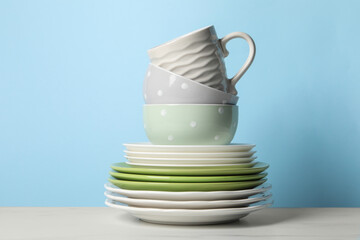 Beautiful ceramic dishware and cup on white marble table