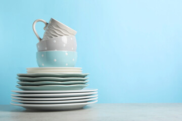 Beautiful ceramic dishware and cup on light grey table, space for text