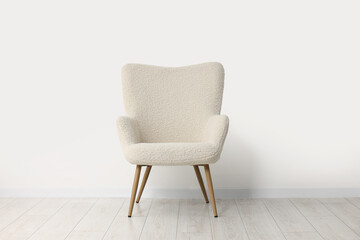 Comfortable armchair near white wall in room