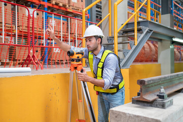 Engineer uses equipment to survey the level of railroad tracks in a maintenance plant.