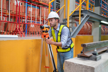 Engineer uses equipment to survey the level of railroad tracks in a maintenance plant.