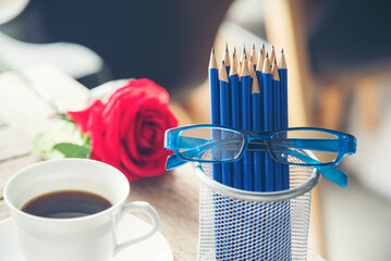 Sharp HB blue pencil silver vase office supply decor coffee cup roses on wood table. Green decorate...