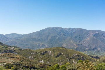 Naklejka premium panoramic view of mountains with vegetation and blue sky