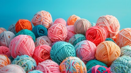 A pile of colorful balls of yarn, arranged in an aesthetically pleasing pattern. The colors include pastel pinks and blues, with some shades of orange and green.