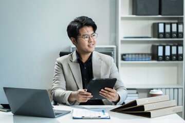 Businessman sitting at his desk in the office, success at work in the office concept.