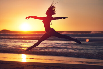 Woman, sunset and jumping silhouette on beach, contemporary dancing and energy in nature with...