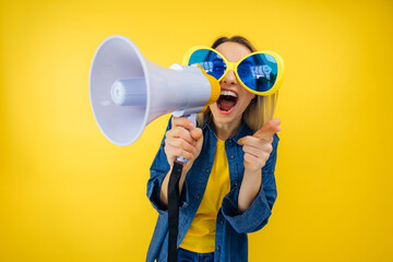 happy vivid young woman in funny large sunglasses scream in megaphone announces discounts sale....