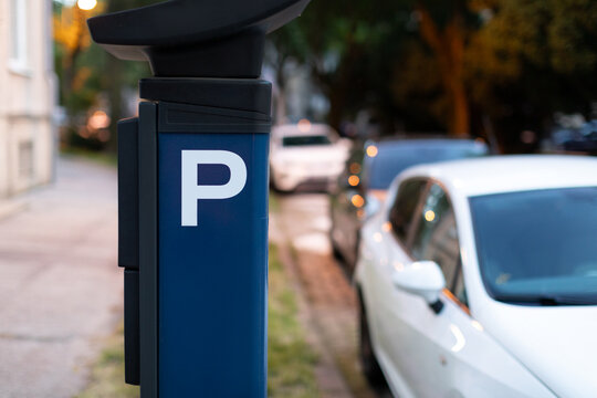 Blue automatic parking ticket machine on city street with blurred cars. Modern technologies concept