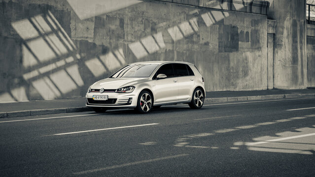 Silver mk7 Volkswagen Golf GTi in front of concrete wall. Three quarter front view of VW hatchback in urban setting. Kyiv, Ukraine - September 06 2014.