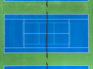 Aerial, drone, photo of new outdoor blue tennis court with white lines combined with light blue...