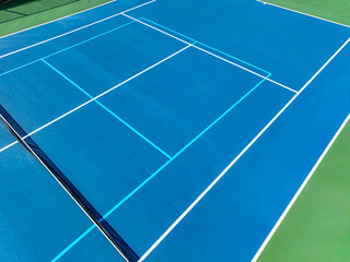 Aerial, drone, photo of new outdoor blue tennis court with white lines combined with light blue...