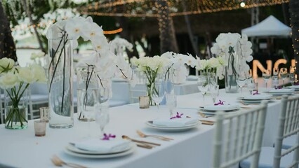 Dinner table setup sunset background. Close up decoration flowers candles Boho style. Romantic wedding reception party outdoor.