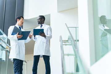 Obraz premium Multinational group wearing white coats talking in the lobby