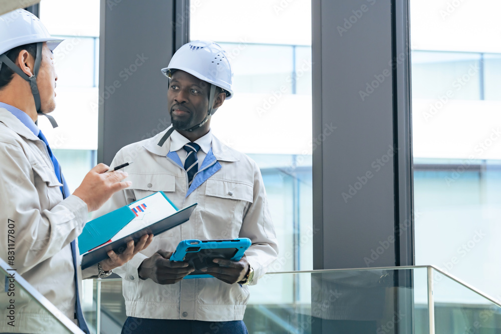 Poster group of multinational engineers having a conversation in a building