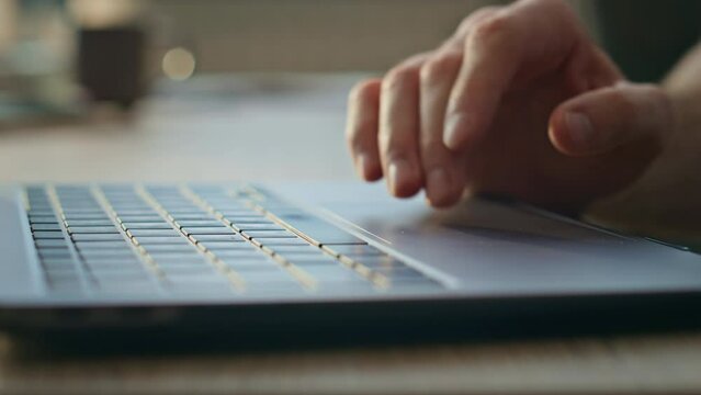Programmer hands using touchpad working on laptop at remote office close up. 