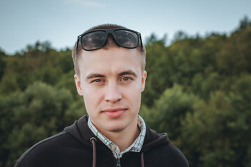 Close-up portrait of a young 20 year man of European appearance with a kind, handsome face looking...