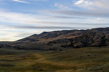Sunset in the Lamar Valley in Yellowstone National Park in Montana and Wyoming on a beautiful fall evening. Sun sets over the mountains and sagebrush with a colorful sky illuminating the landscape.