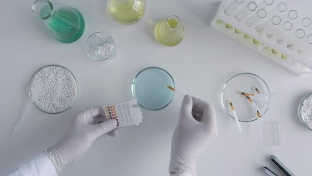 Top view a scientist in a chemical laboratory takes measurements of the acid-base balance of a liquid.