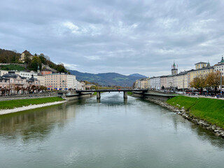 Marko-Feingold-Steg bridge above the Salzach River with the city shoreline in Salzburg, Austria, highlighting the bridge's modern design and scenic urban backdrop.