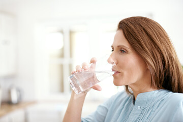 Home, kitchen and woman with drinking water in glass for minerals, hydration and healthy diet....