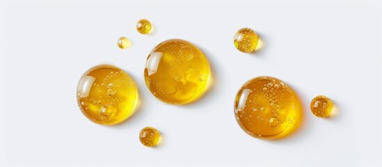 Small drops of yellow oil isolated on a white background