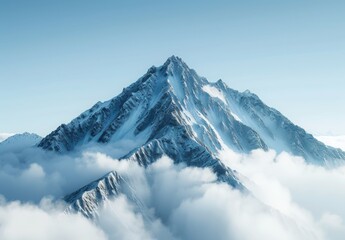 Obraz premium A mountain peak surrounded by wispy clouds with a clear blue sky above. The majestic landscape provides plenty of room for inspirational messages about reaching new heights and aspirations.