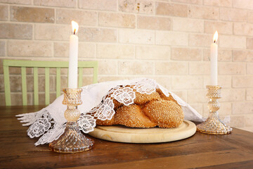 shabbat image. challah bread and candles on wooden table