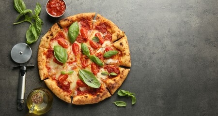 Delicious Margherita pizza, ingredients and cutter on grey table, top view. Space for text