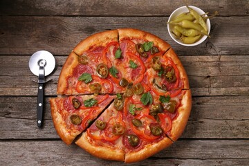 Delicious pizza Diablo, pickled peppers and cutter on wooden table, flat lay