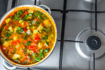 a saucepan full of traditional  Romanian vegetable soup on a gas stove