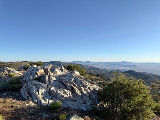 Panoramic Rocky Mountain crest view showcasing jagged peaks under a vibrant blue sky, an awe-inspiring backdrop of nature’s majesty