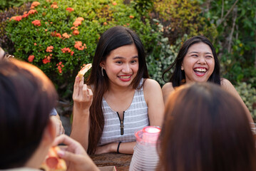 Young people hanging out, gorging and feasting on pizza and drinks during a nice intimate picnic...