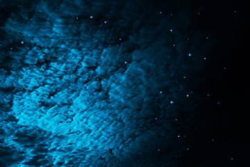 Black dark blue night starry sky with clouds background. Starlight and moonlight. Dramatic cloudy...