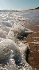Close-up of sea foam on sandy beach
