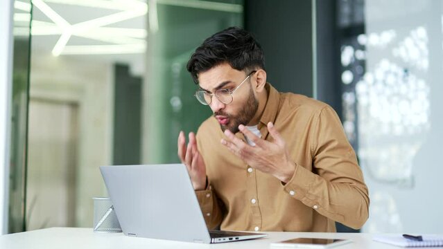 Worried angry businessman having problems with software or service on laptop computer sitting at workplace in business office Frustrated disappointed man worker complains about bad internet connection