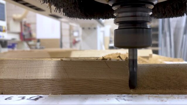 Close-up of the milling process of MDF, particleboard, and plywood on a CNC machine. Industrial production of furniture and interior design elements made of wood. A 3D milling machine in operation.